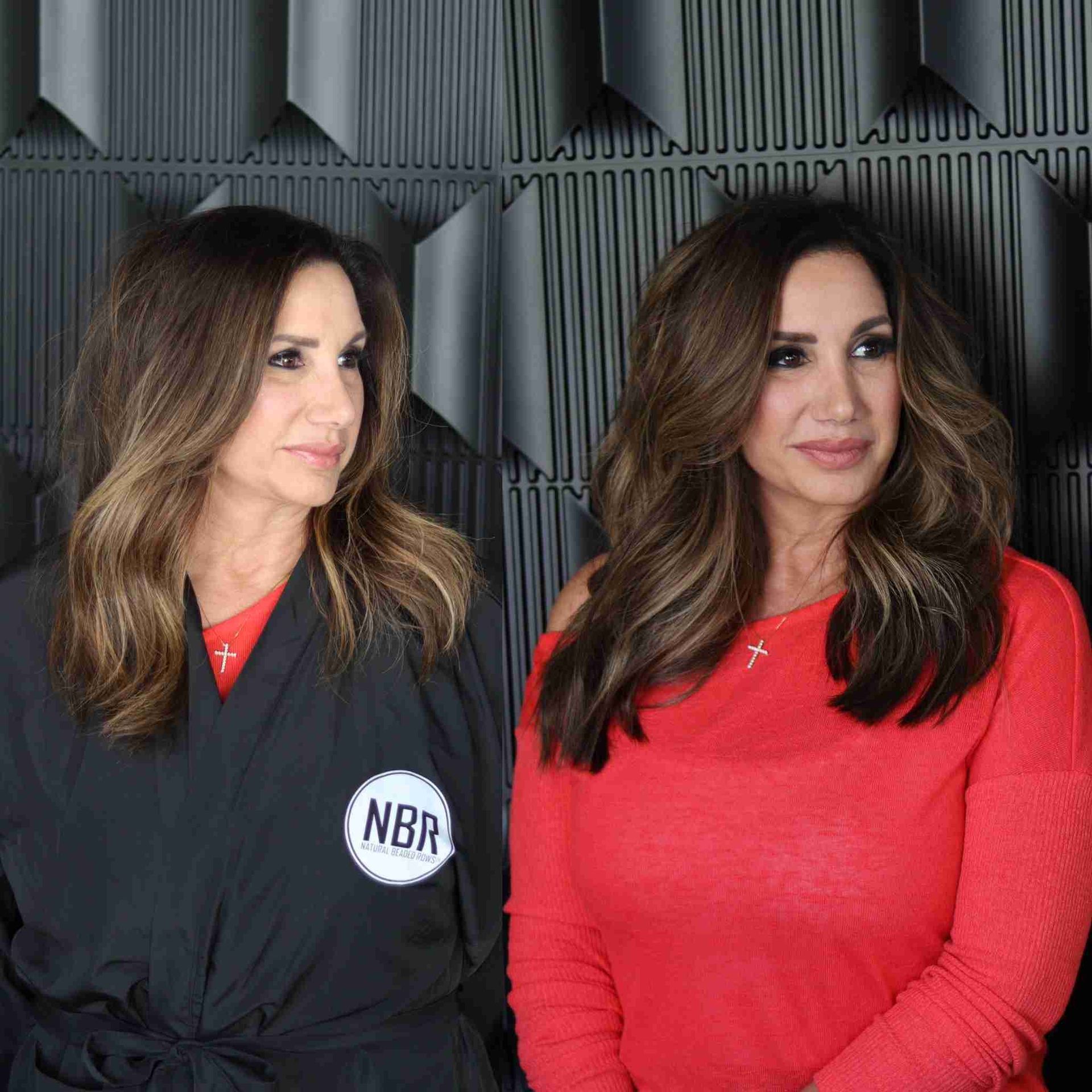 Two women are standing next to each other in front of a black wall.