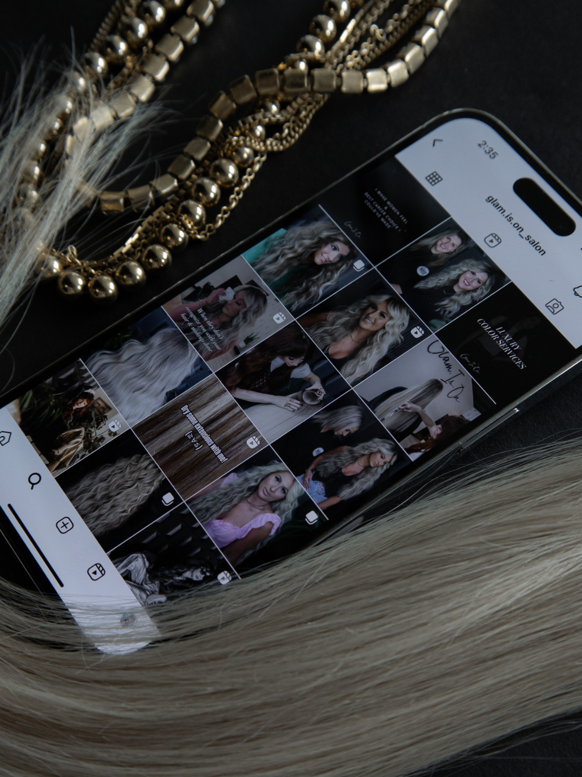 A cell phone is sitting on a table next to a necklace.