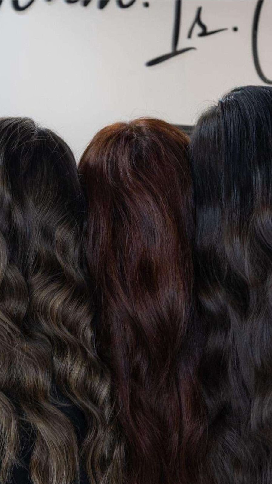 A group of women with long hair are standing next to each other.