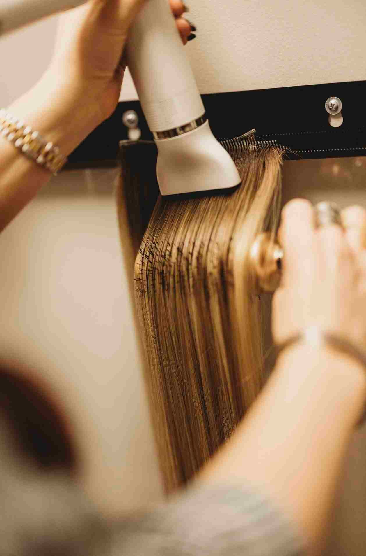 A person is holding a hair dryer over a radiator.