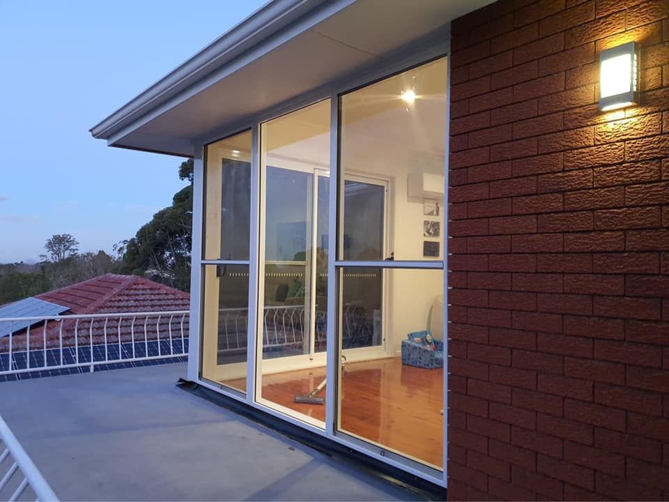 A Living Room with Sliding Glass Doors — Distinctive Glass & Aluminium in Port Kembla, NSW