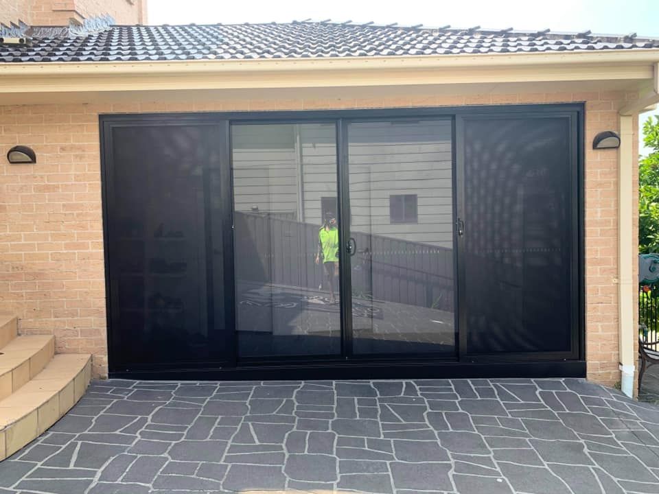 A Brick Building with A Sliding Glass Door — Distinctive Glass & Aluminium in Kiama, NSW