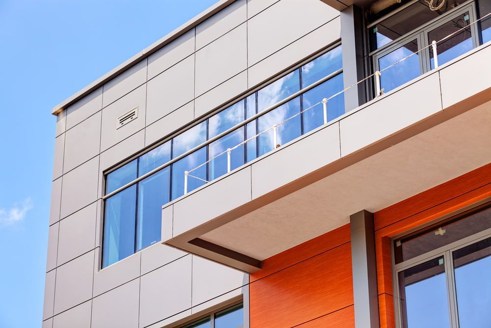 A Large Building with A Lot of Windows and A Balcony — Distinctive Glass & Aluminium in Dapto, NSW