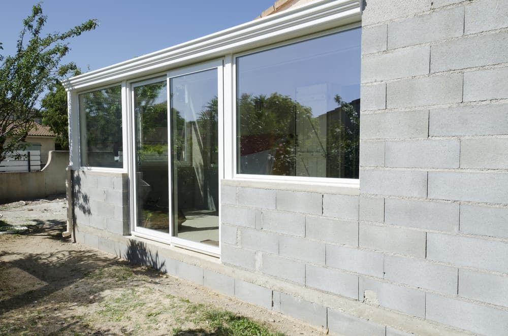 A Brick Building with A Sliding Glass Door — Distinctive Glass & Aluminium in Thirroul, NSW