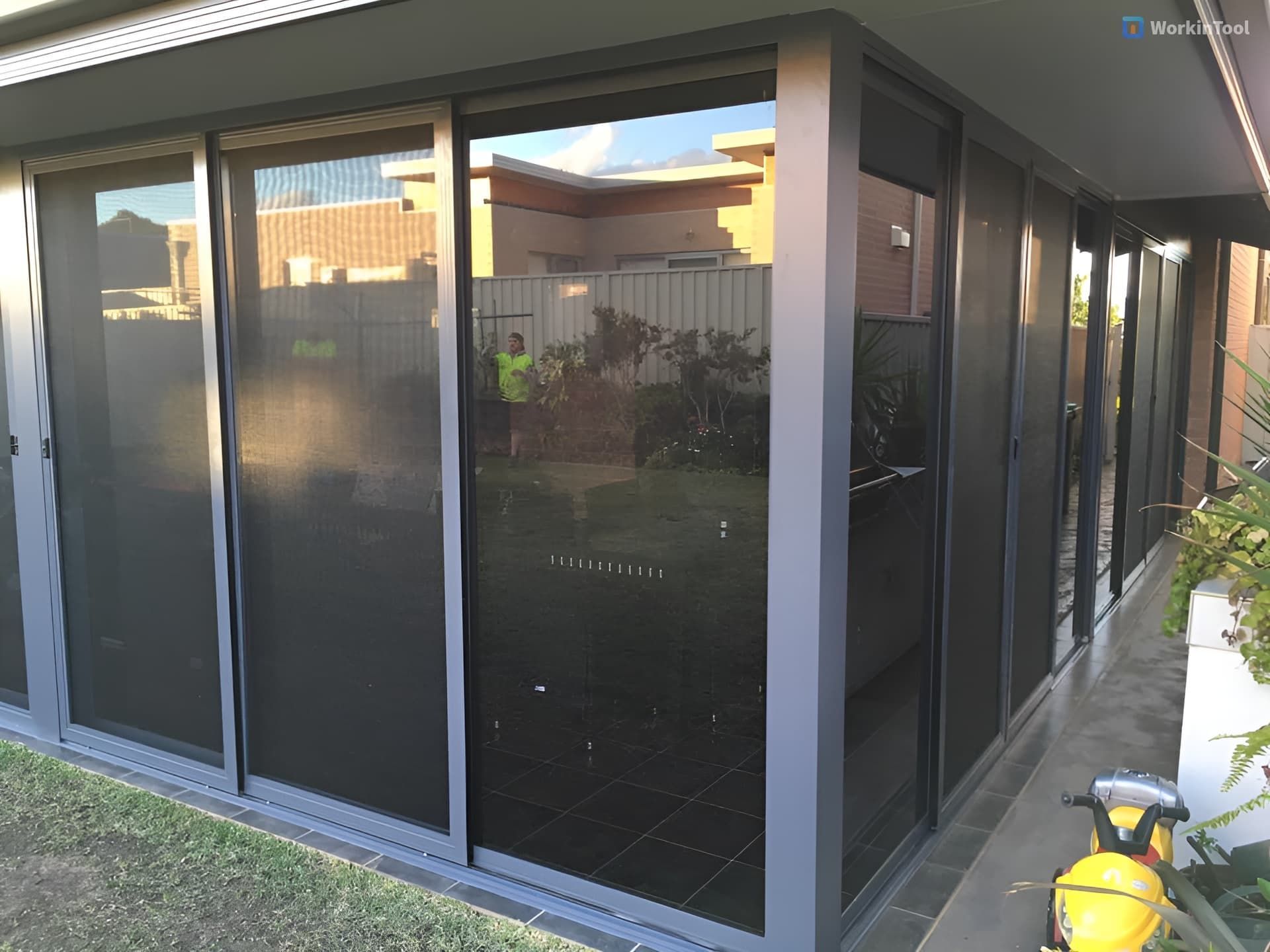 A House with A Lot of Windows and A Motorcycle Parked in Front of It — Distinctive Glass & Aluminium in Kiama, NSW