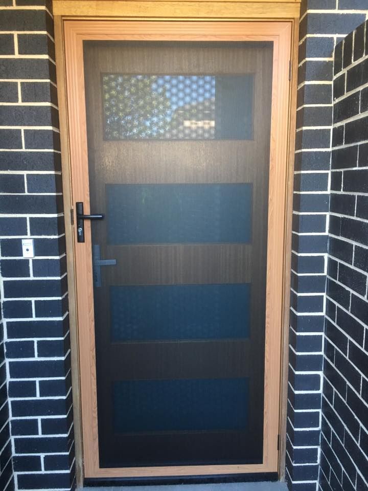 A Screen Door with A Brick Wall Behind It — Distinctive Glass & Aluminium in Thirroul, NSW