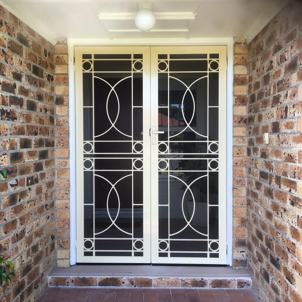 A Brick Wall with A White Door and A Ceiling Fan — Distinctive Glass & Aluminium in Kiama, NSW
