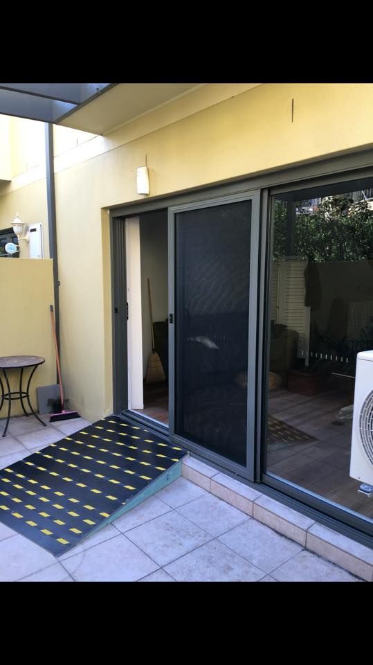 A Patio with A Sliding Glass Door and A Table — Distinctive Glass & Aluminium in Dapto, NSW