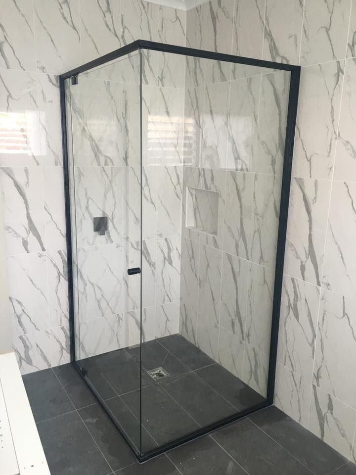 A Shower Stall with A Black Frame and Marble Walls — Distinctive Glass & Aluminium in Port Kembla, NSW