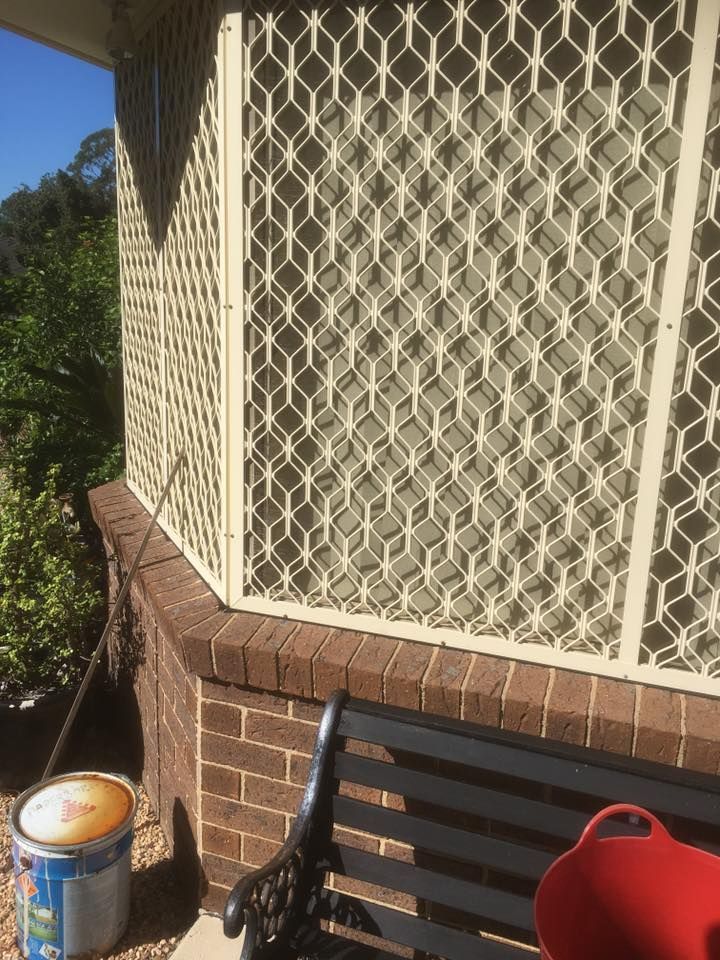 A Bucket of Paint Is Sitting on A Bench Next to A Window — Distinctive Glass & Aluminium in Thirroul, NSW