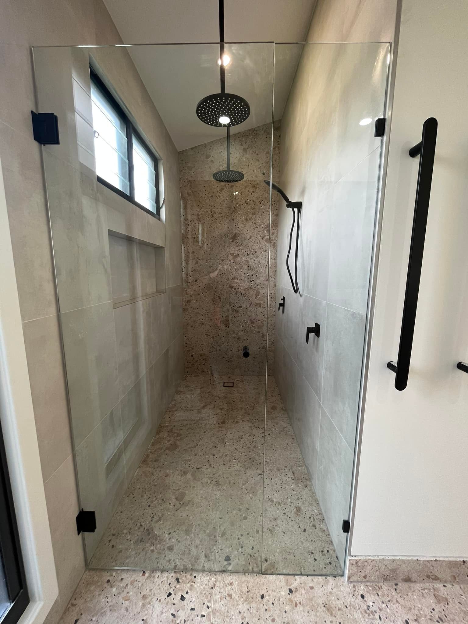 A Bathroom with Marble Tiles and A Shower Stall — Distinctive Glass & Aluminium in Port Kembla, NSW