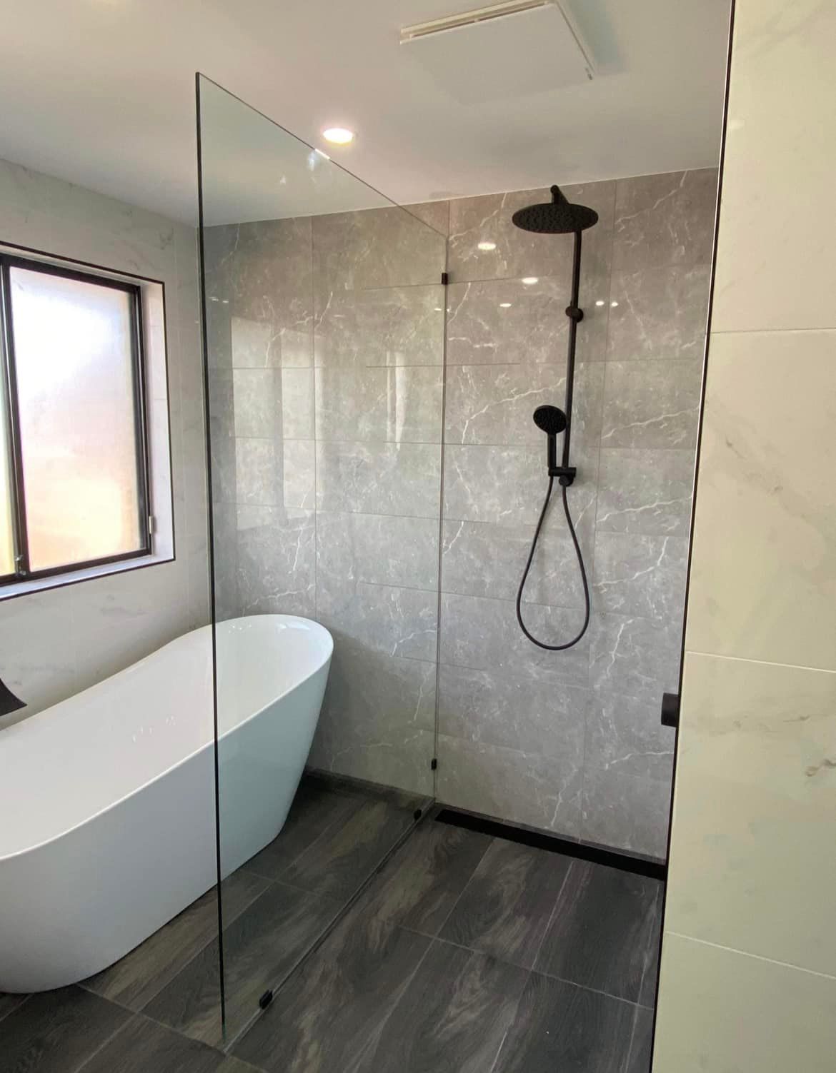 A Bathroom With a Bathtub and a Walk in Shower — Distinctive Glass & Aluminium In Port Kembla, NSW