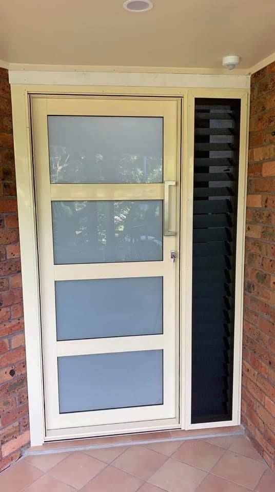 A White Door with A Black Screen on The Side — Distinctive Glass & Aluminium in Port Kembla, NSW
