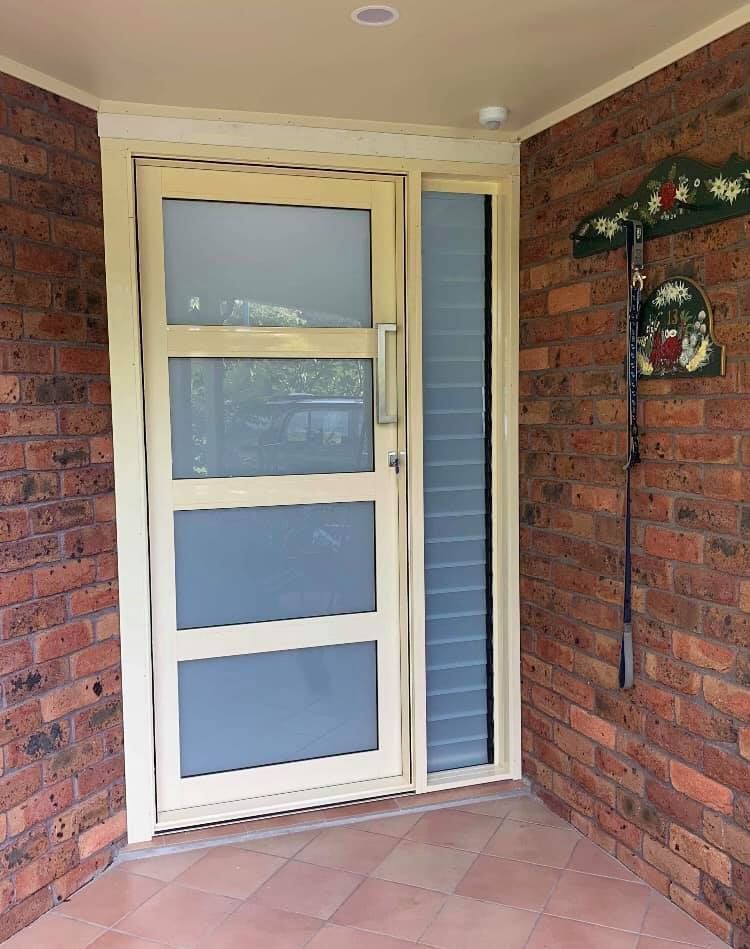 A White Door with A Brick Wall Behind It — Distinctive Glass & Aluminium in Dapto, NSW