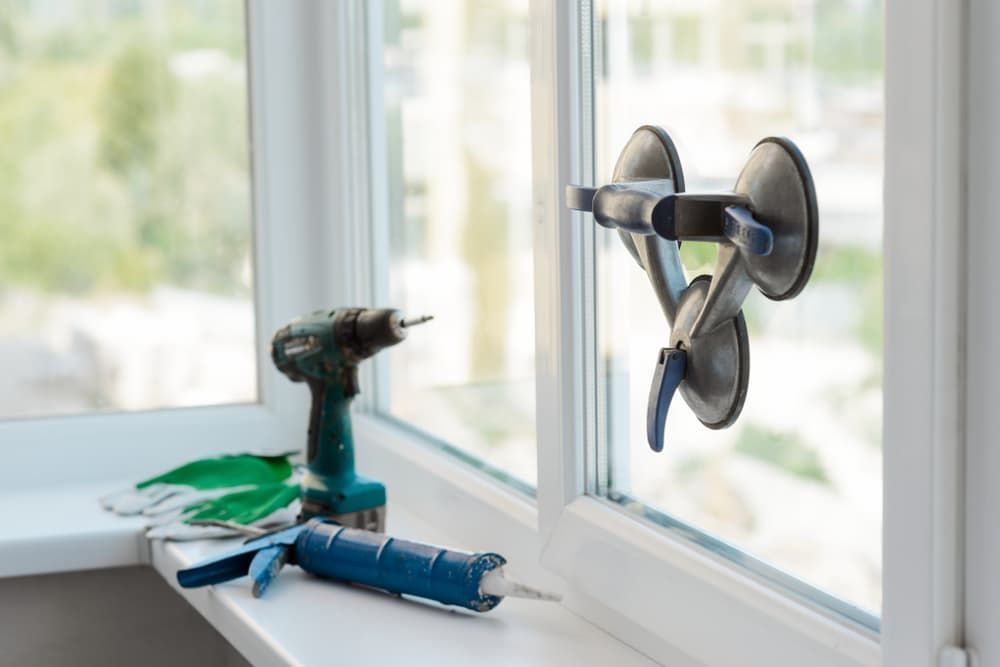 A Drill and A Vacuum Cleaner Are Sitting on A Window Sill — Distinctive Glass & Aluminium in Thirroul, NSW