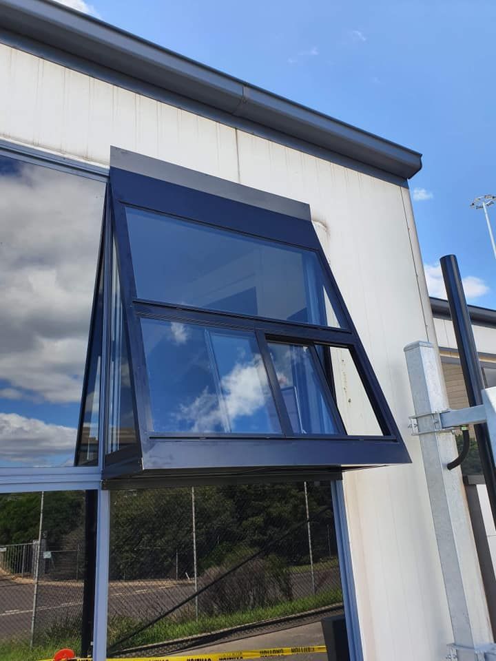 A Large Window on The Side of A Building with A Blue Sky — Distinctive Glass & Aluminium in Thirroul, NSW