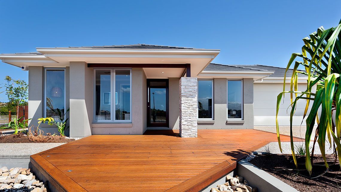 A White House with A Wooden Deck in Front of It — Distinctive Glass & Aluminium in Port Kembla, NSW