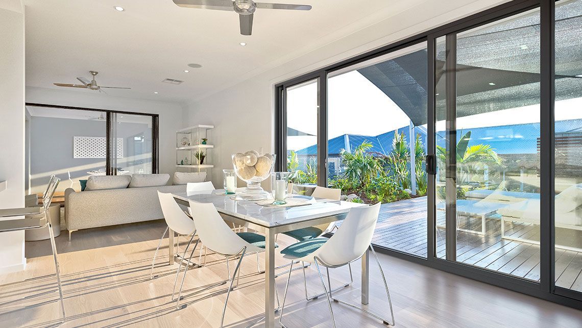 A Living Room with A Dining Table and Chairs and A Ceiling Fan — Distinctive Glass & Aluminium in Shellharbour, NSW