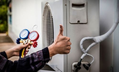 Person giving thumbs up next to an AC unit, holding gauges.
