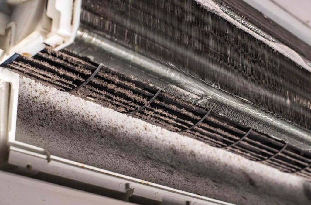 Dirty air conditioner unit with visible dust and debris on the coils.