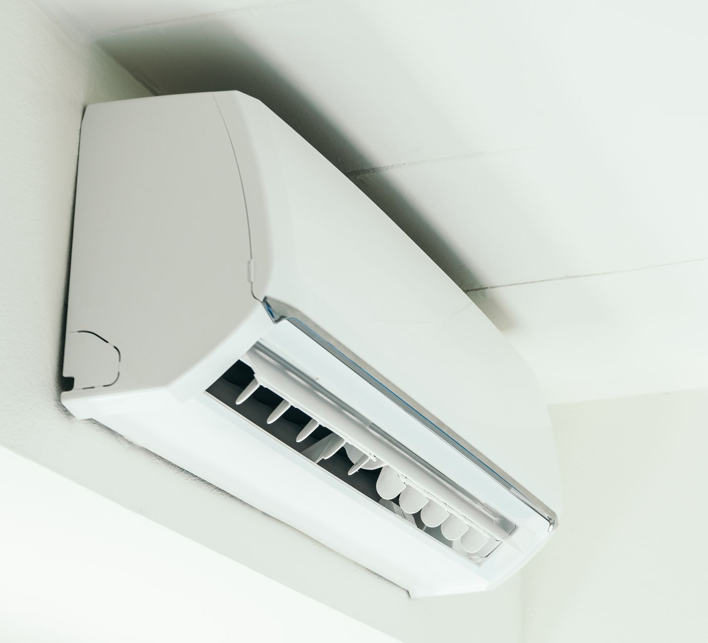 A white wall-mounted split system air conditioner installed in the corner of a room.