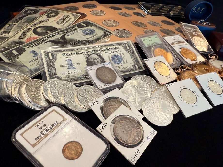 Collection of old currency, including paper bills and silver and gold coins.
