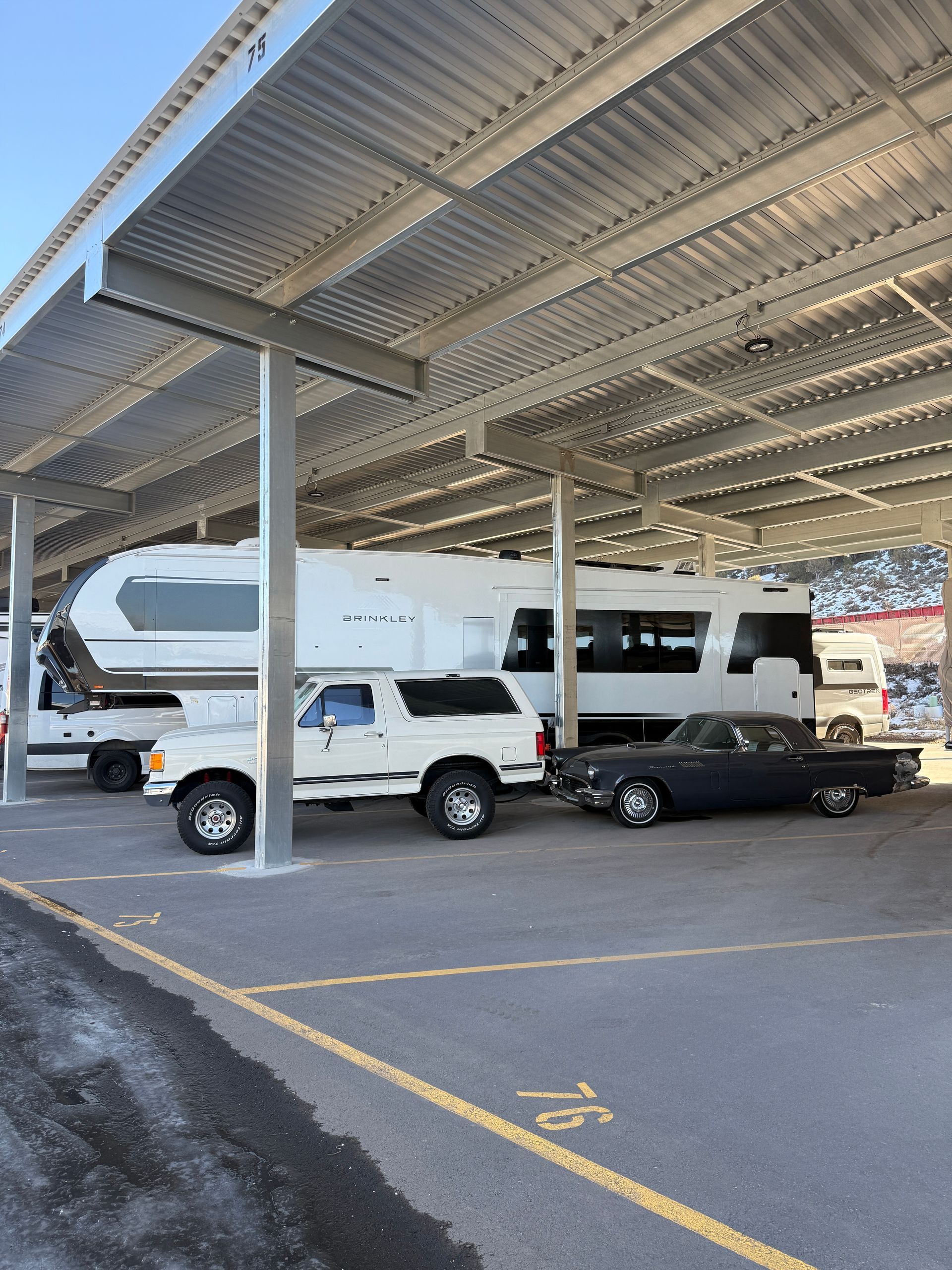 Fifth-wheel RV and truck stored under covered parking with power at Eagle Canopy