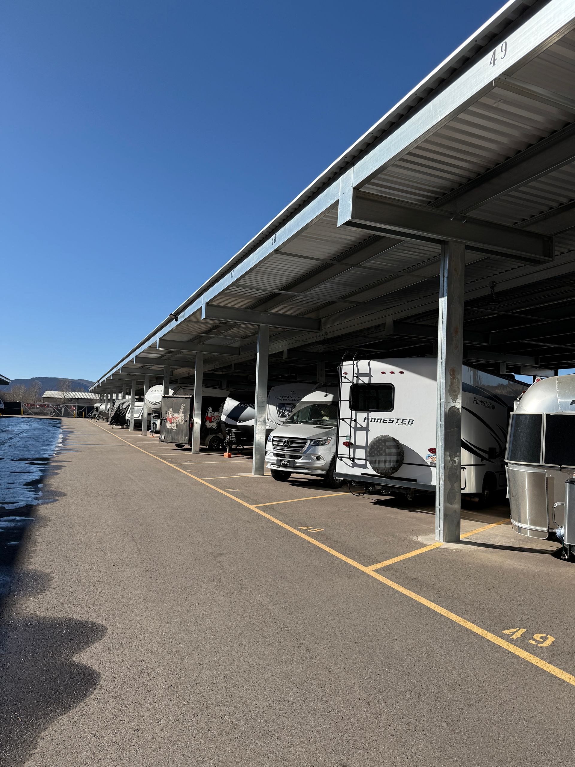 Multiple RVs and trailers parked under covered canopy at Eagle Canopy