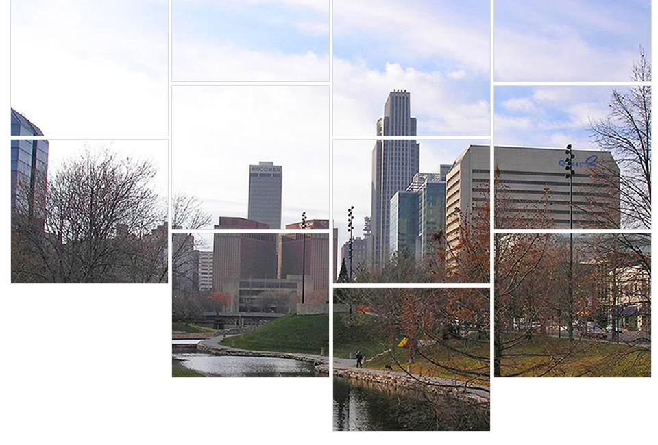 City skyline view with buildings, trees, and cloudy sky.