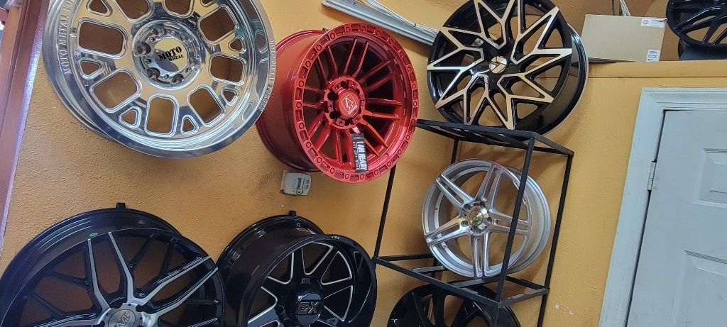 A bunch of wheels are hanging on a wall.