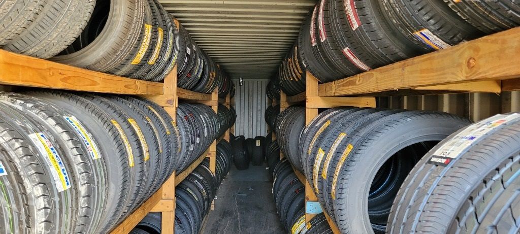 A warehouse filled with lots of used tires on wooden shelves.