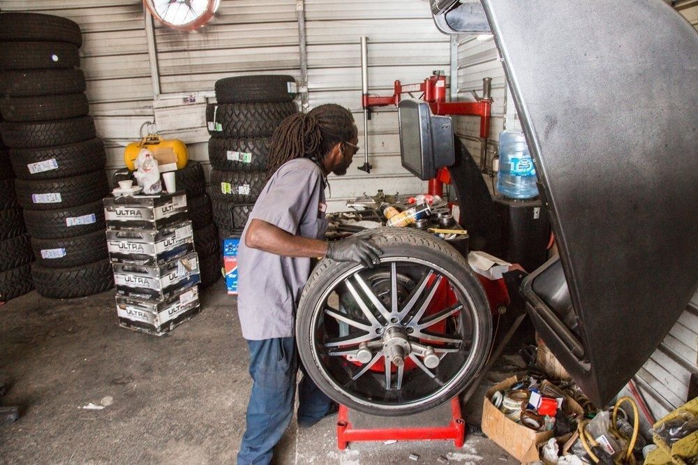 A man is balancing a tire in a garage.