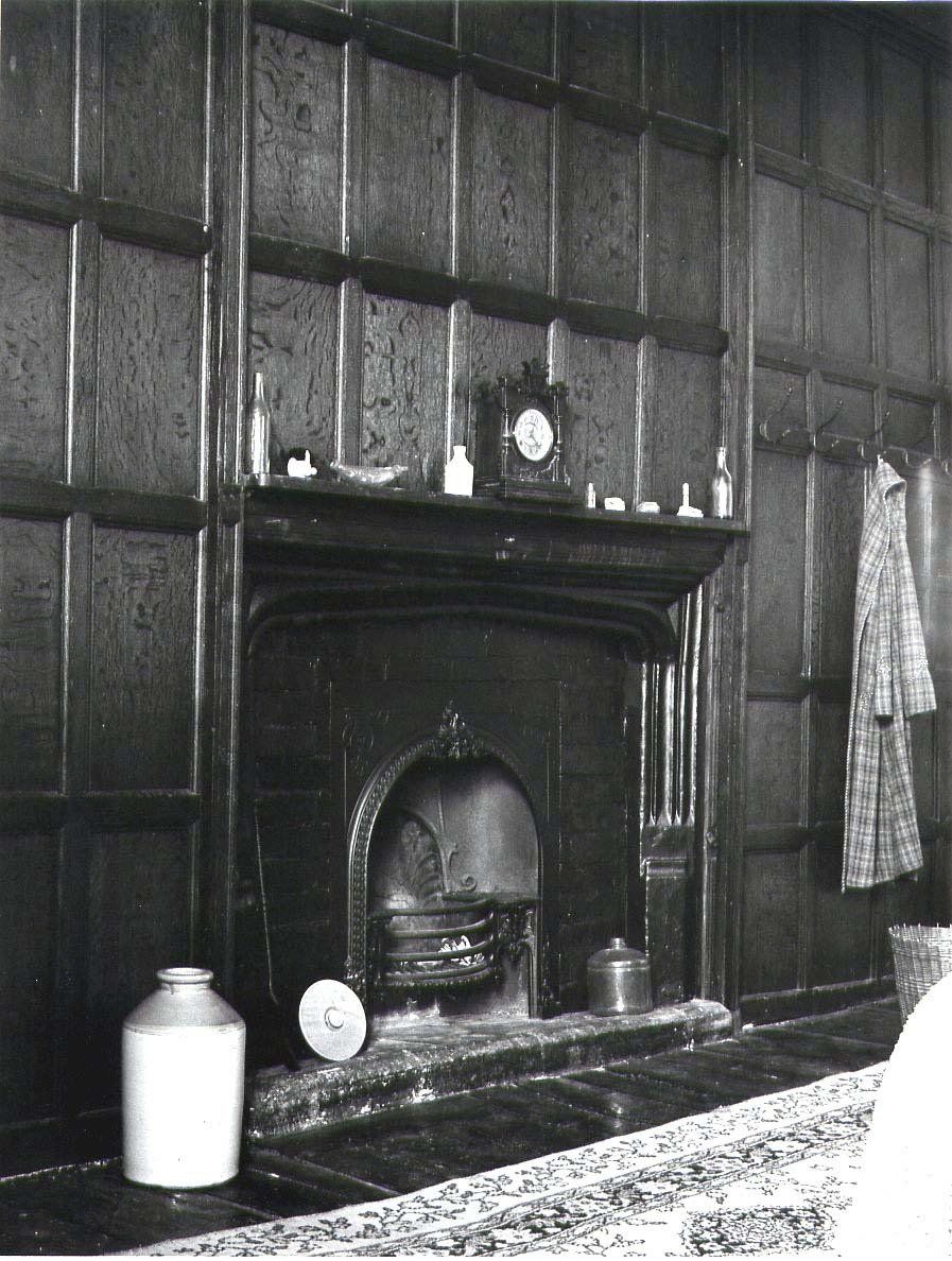 A black and white photo of a fireplace at Acton Court