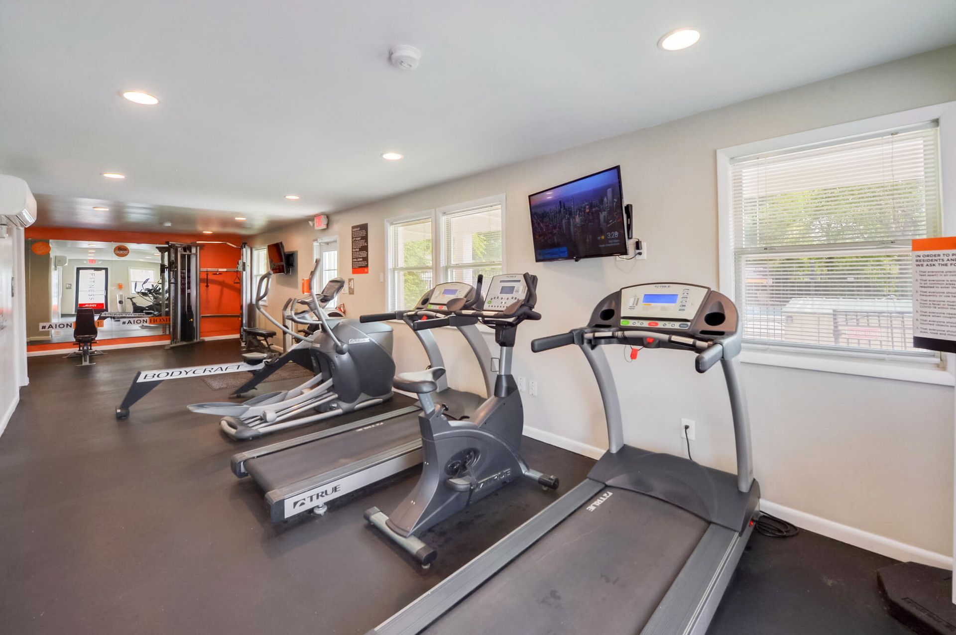 Interior view of a community gym with treadmills and ellipticals.