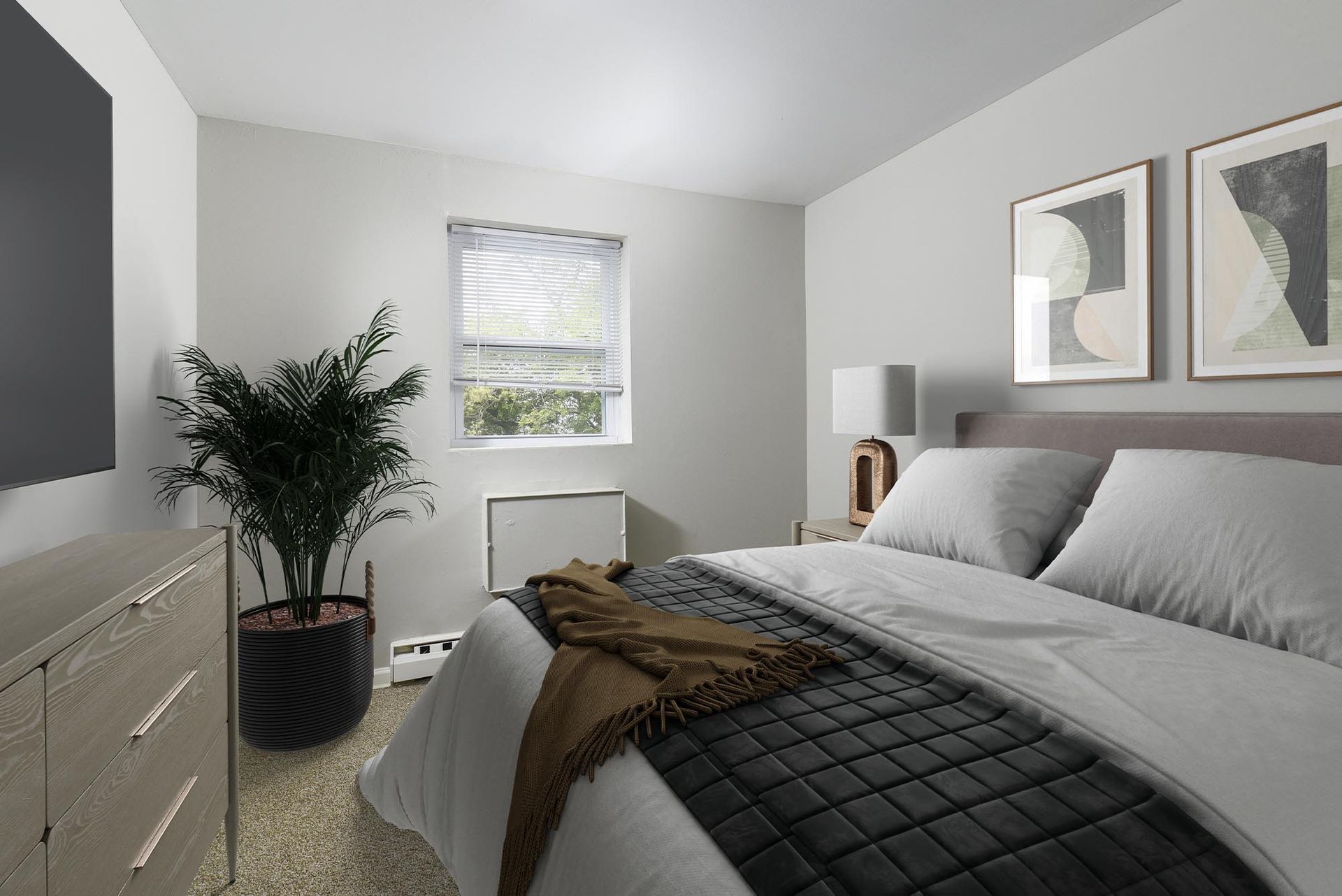 Bedroom in an apartment with a bed, dresser, plant, and window.