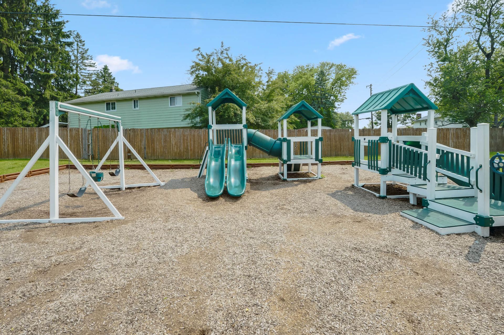 Outdoor community playground with swings, slides, and climbing structures.