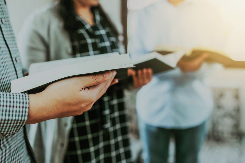 Three People Holding Bible — Yeadon, PA — Chapel of the Good Shepherd