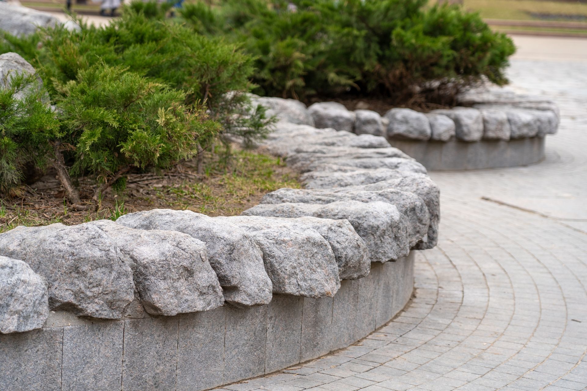 Black trash bags and wood debris in front of a white garage door.