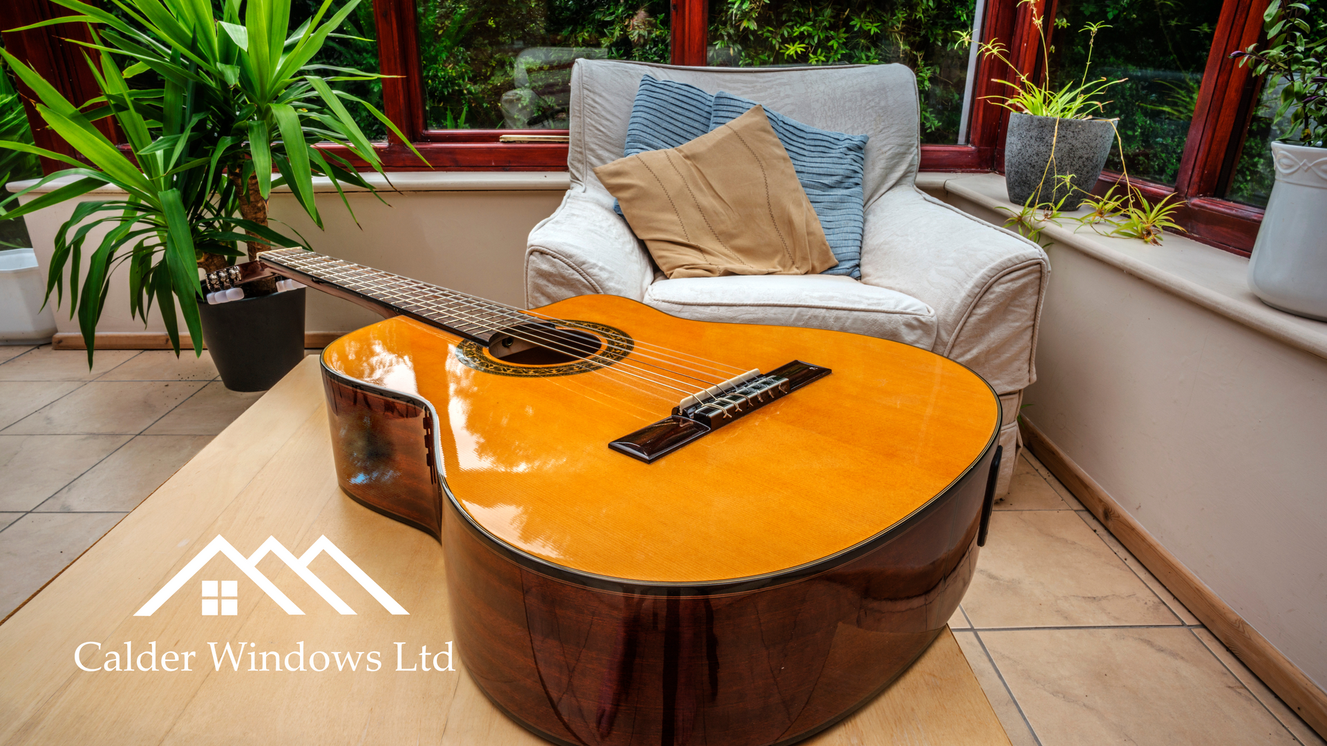 Orange acoustic guitar on a round coffee table in a bright patio seating area