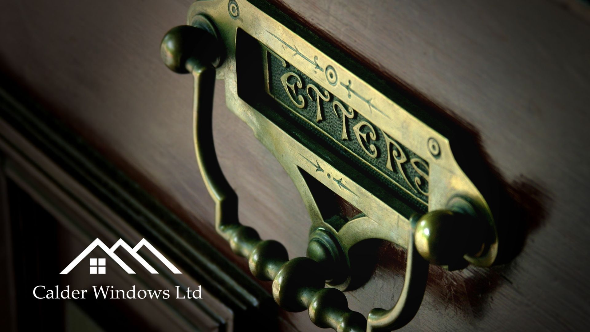Close-up of a brass stair plaque and dark metal handle on a wooden door