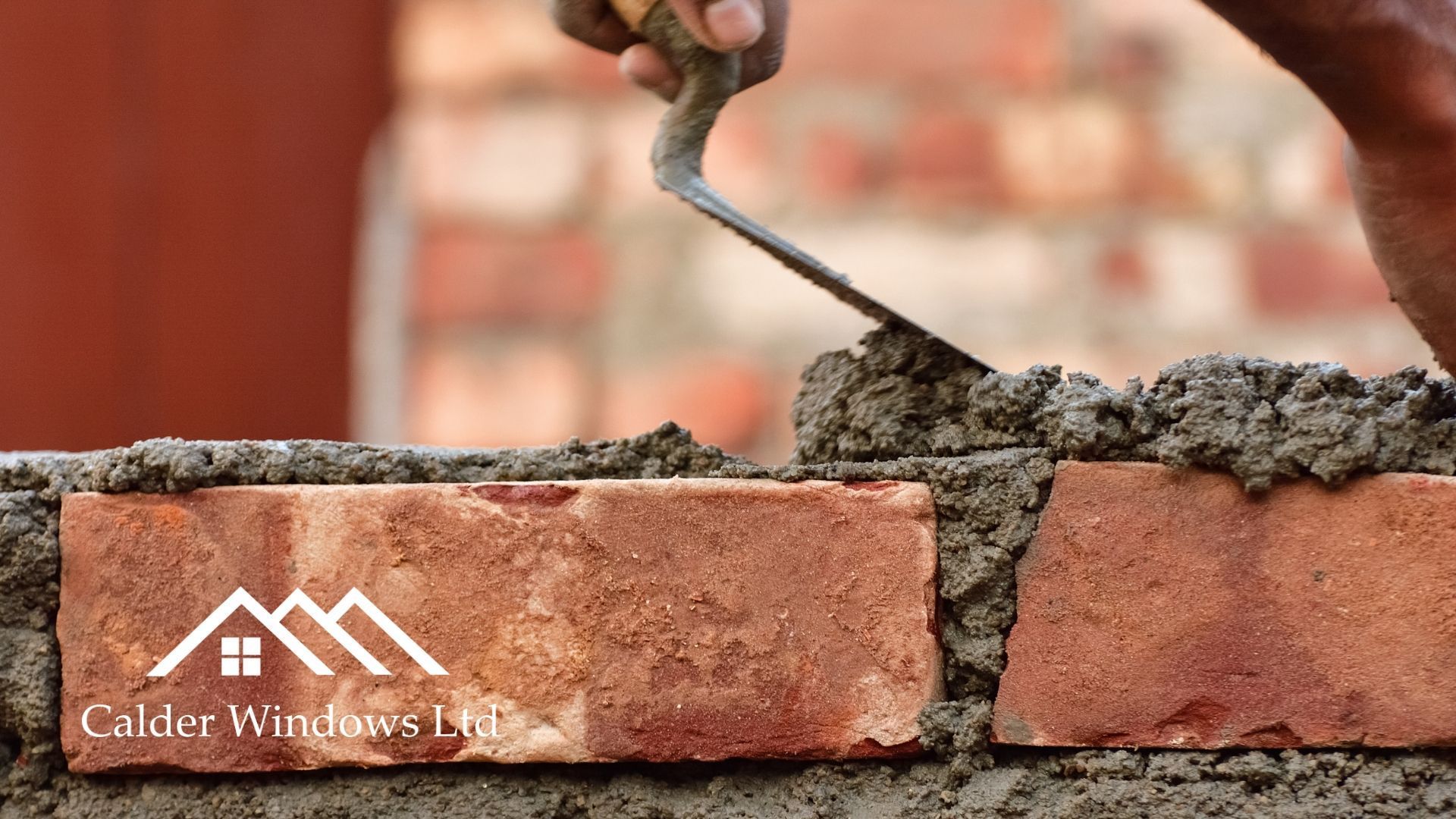 Trowel spreading wet mortar on a brick wall during masonry work