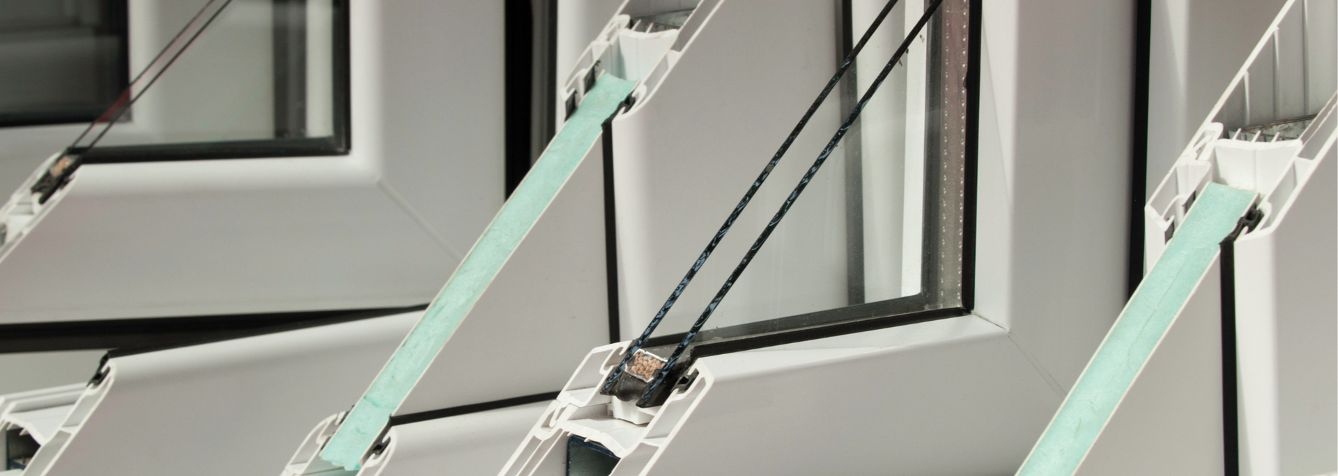 Mint-green window wiper arms attached to a white building facade with black-framed windows.