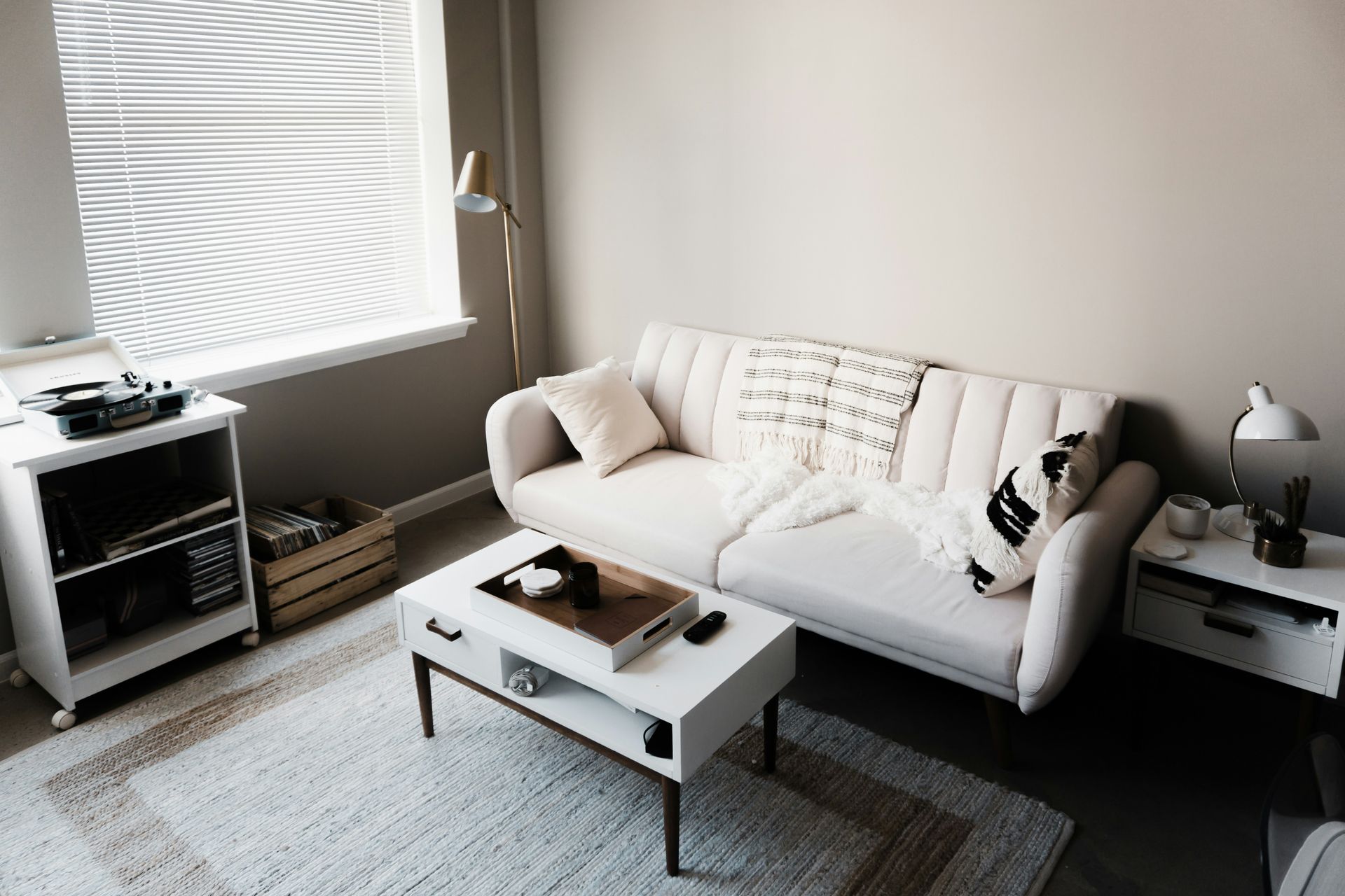 A living room with a white couch and a white coffee table.