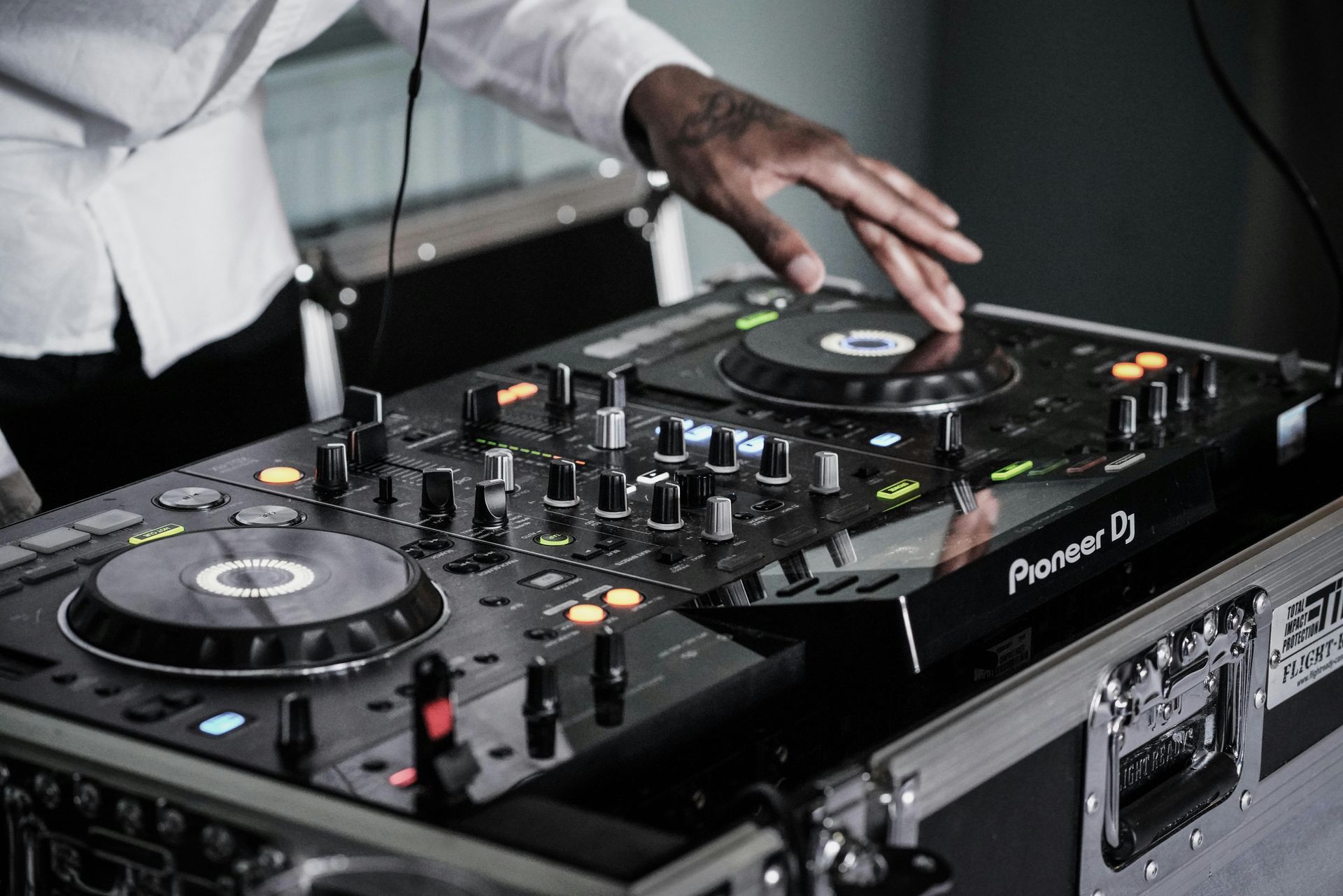 A dj is playing music on a pioneer dj controller.