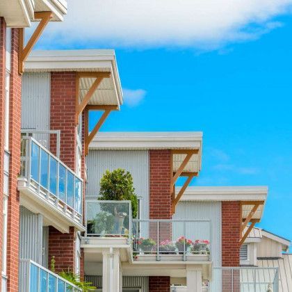 A row of apartment buildings with balconies on a sunny day.