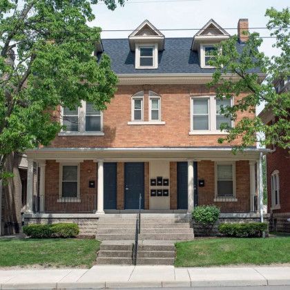 A large brick house with stairs leading up to it