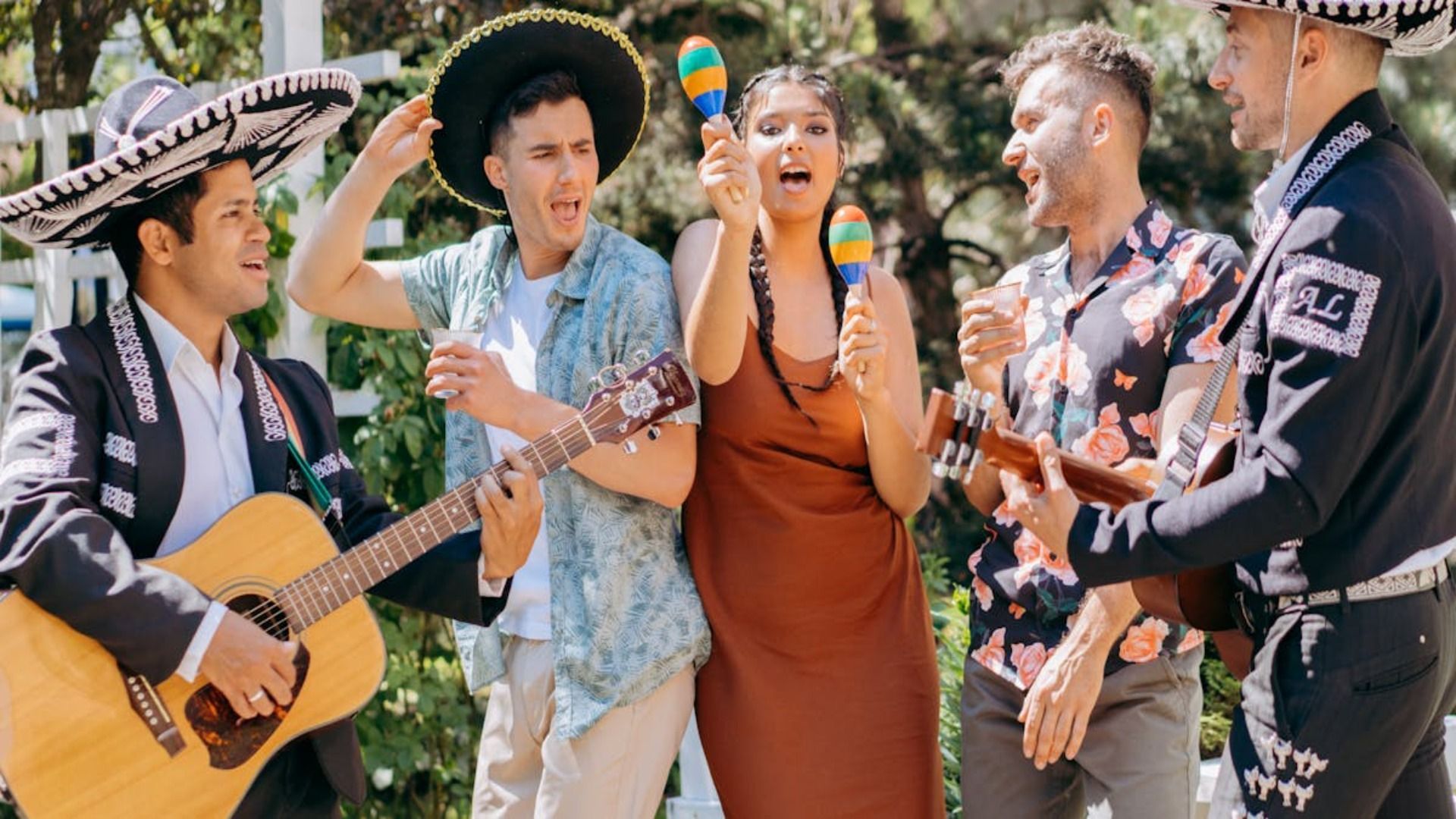 Un grupo de personas está de pie alrededor de un hombre que toca una guitarra.