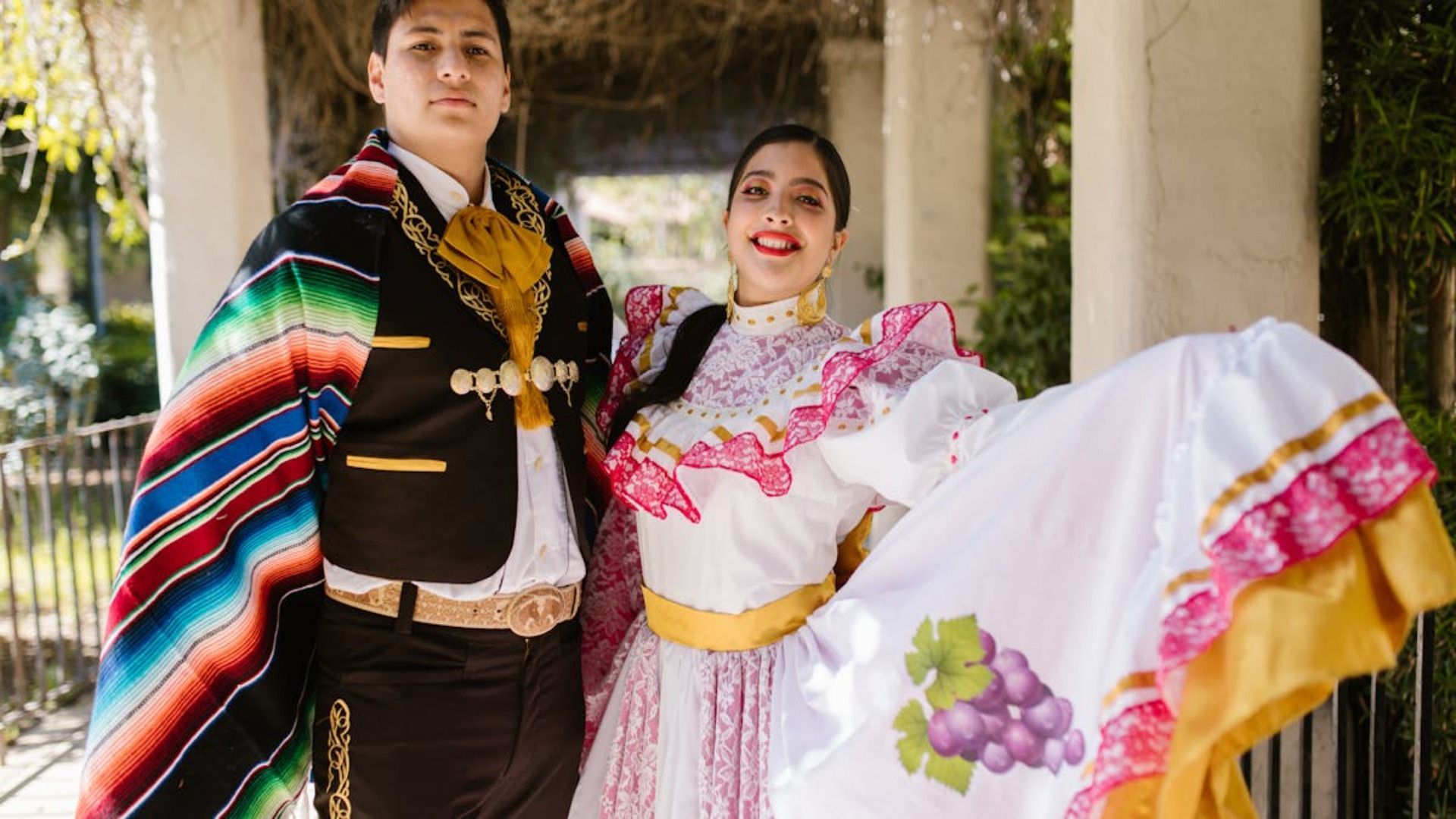Un hombre y una mujer con trajes tradicionales mexicanos posan para una fotografía.
