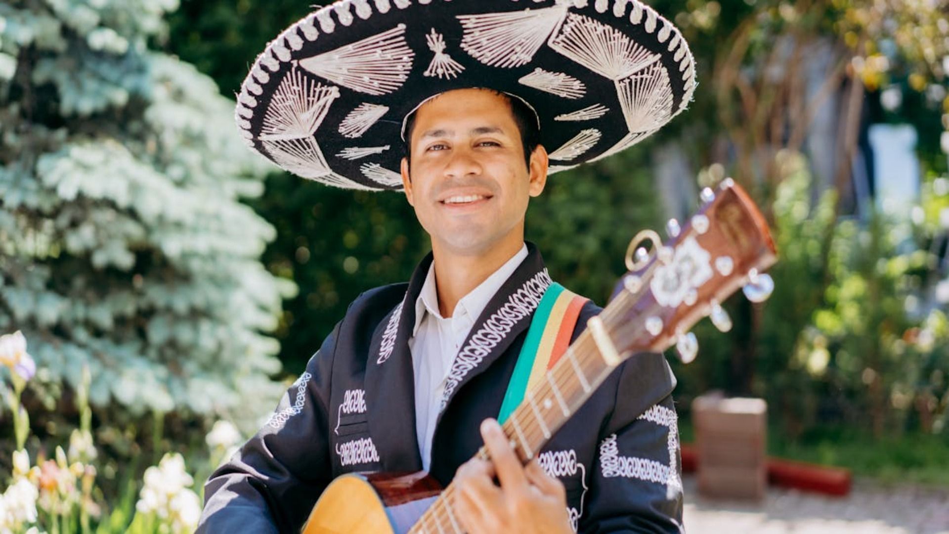 Un hombre que lleva un sombrero está tocando una guitarra.