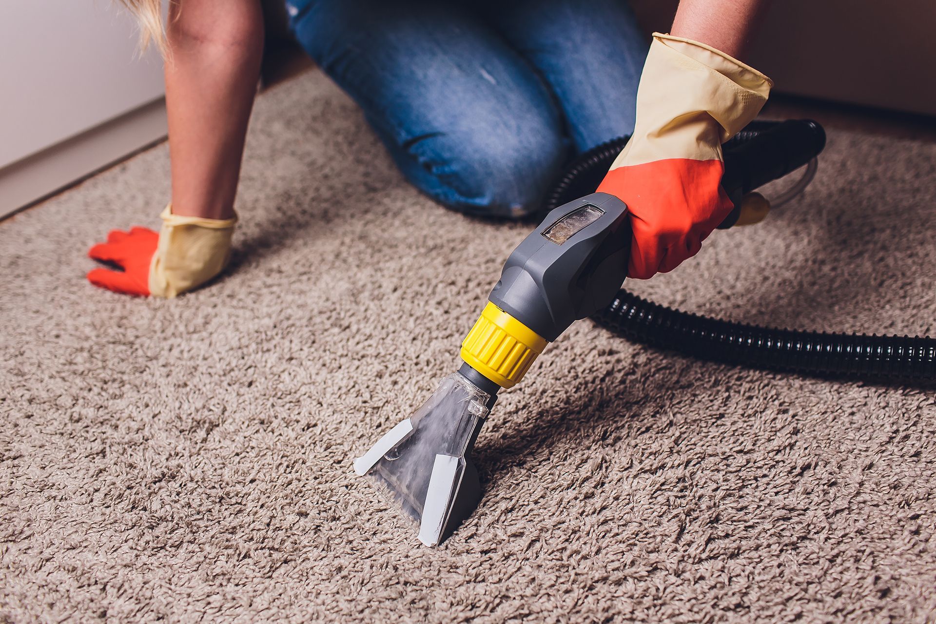 A Woman Is Cleaning a Carpet with A Vacuum Cleaner